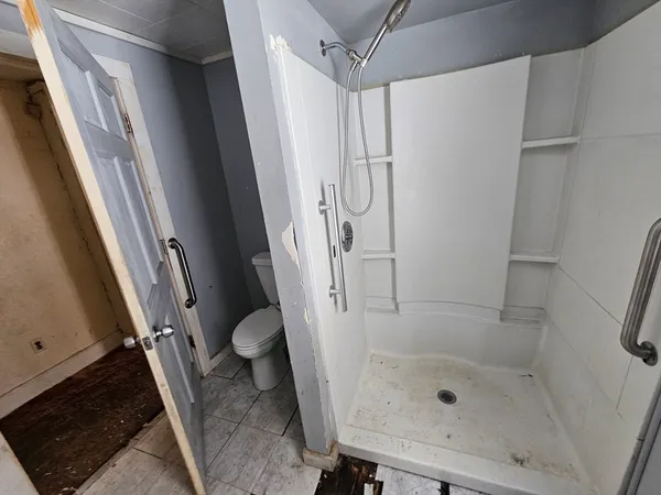 a bathroom with a toilet and a shower