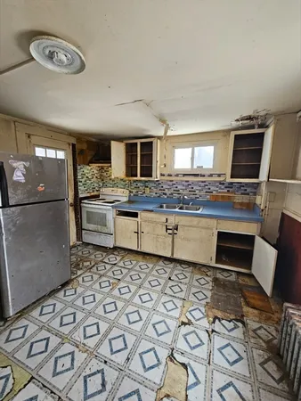 a kitchen with stainless steel appliances a stove a sink and a refrigerator