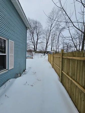 a view of snow on the road and trees