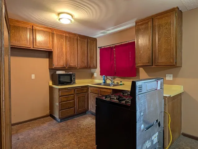 a kitchen with stainless steel appliances granite countertop a refrigerator stove top oven a sink and dishwasher