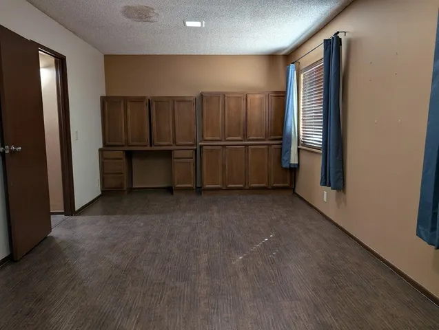 a view of kitchen with cabinets and refrigerator