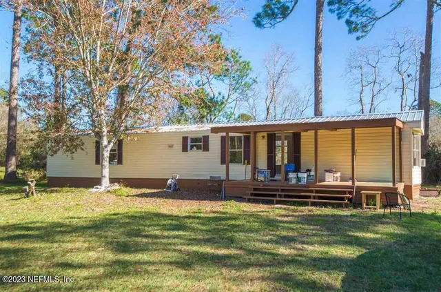 a view of an empty room with window wooden floor and a kitchen