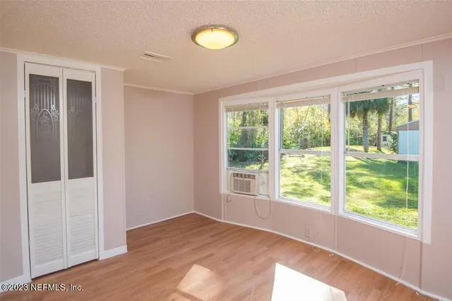 a view of a small house with a small yard and wooden fence