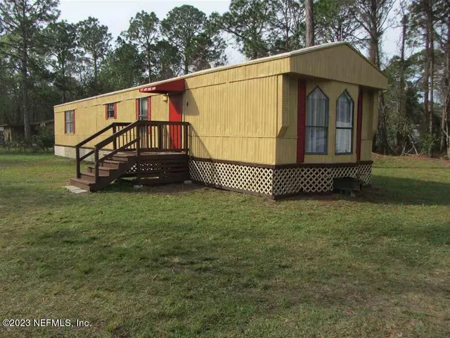 a view of a hallway with wooden floor and a large mirror