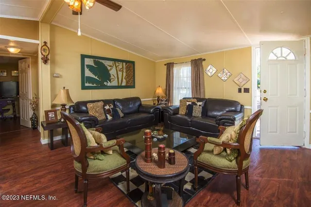 a living room with furniture a chandelier and a lamp