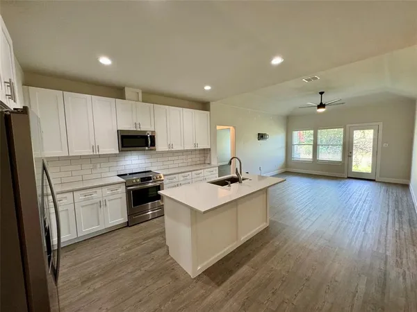 a kitchen with stainless steel appliances granite countertop a sink stove and refrigerator