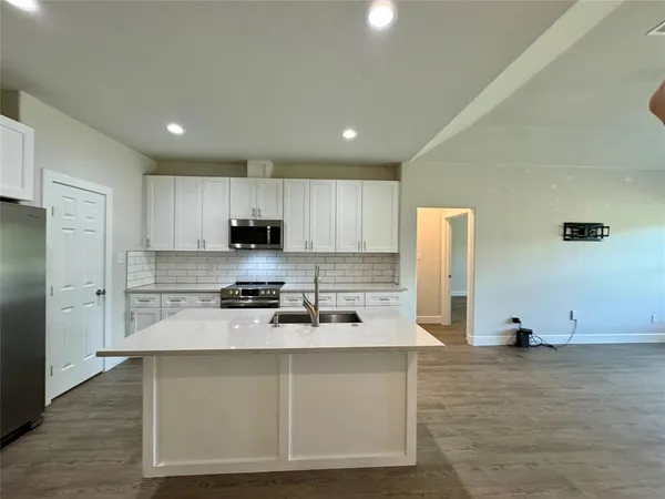 a kitchen with stainless steel appliances granite countertop a stove a sink and a refrigerator