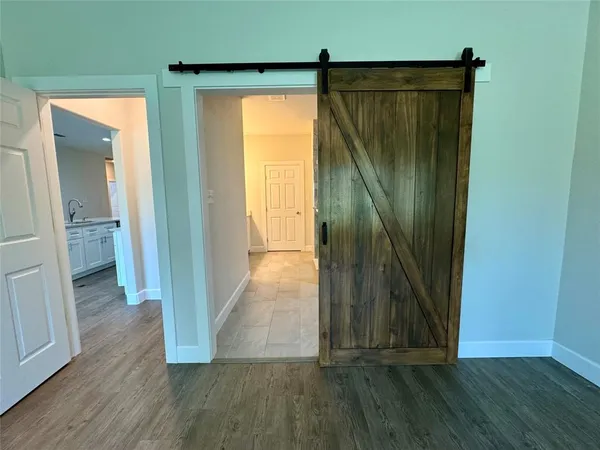 a view of a hallway with wooden floor and a glass door