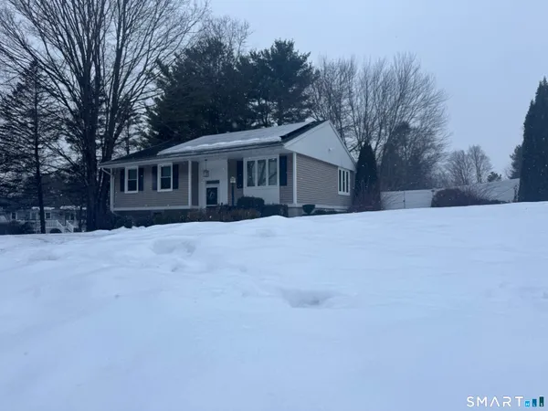 a view of house with a yard covered in snow