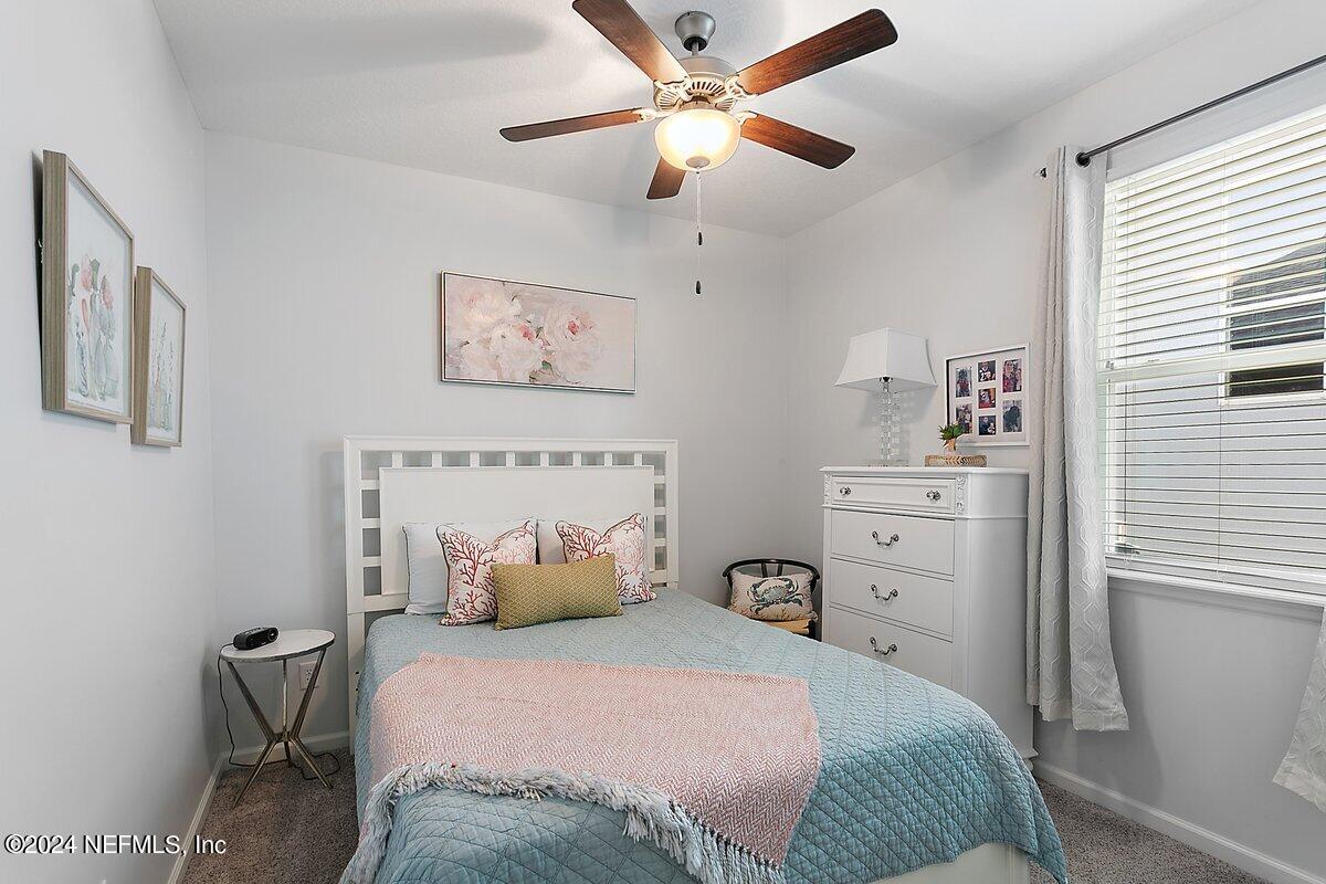 14720 Trellis Street Jacksonville, FL 32258 - Photo 12 of 21 a bedroom with a bed and a chandelier
