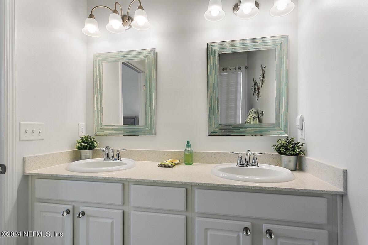 14720 Trellis Street Jacksonville, FL 32258 - Photo 16 of 21 a bathroom with double vanity sinks and a mirror