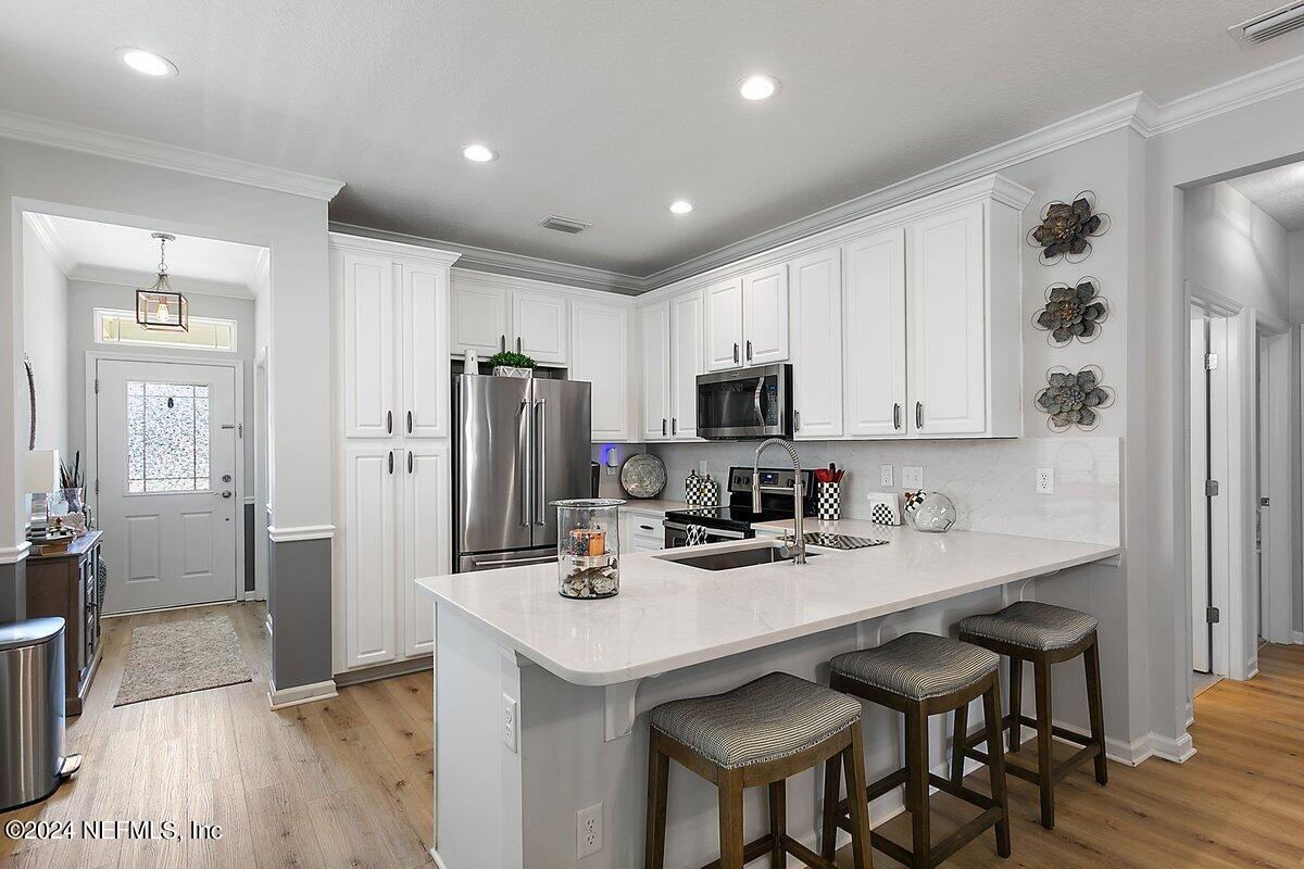 14720 Trellis Street Jacksonville, FL 32258 - Photo 8 of 21 a kitchen with stainless steel appliances kitchen island granite countertop a sink cabinets and wooden floor