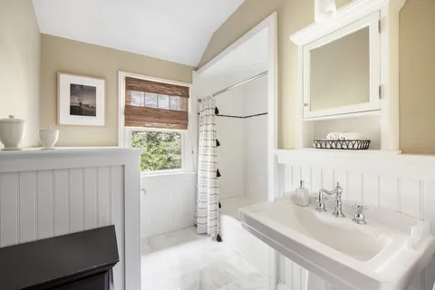 a bathroom with a sink a mirror and a shower