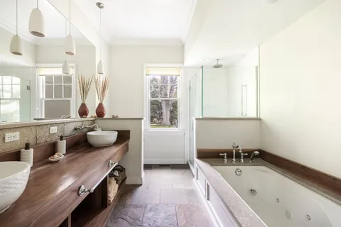 a bathroom with a tub sink and mirror