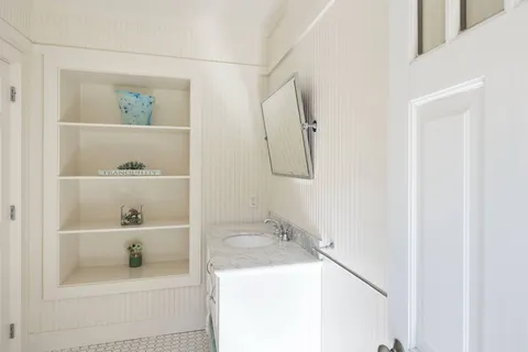 a bathroom with a sink a toilet and a mirror