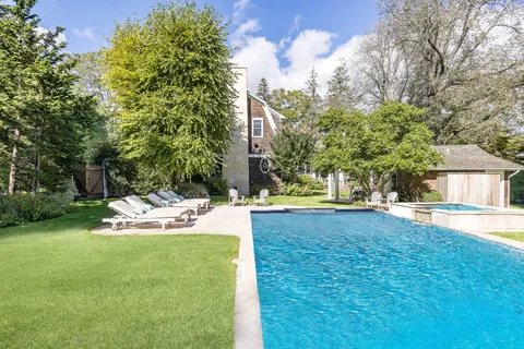 a view of a house with swimming pool and sitting area