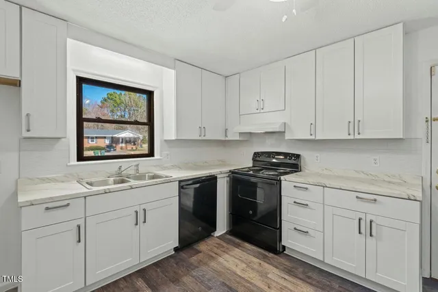 a kitchen with white cabinets appliances and a sink