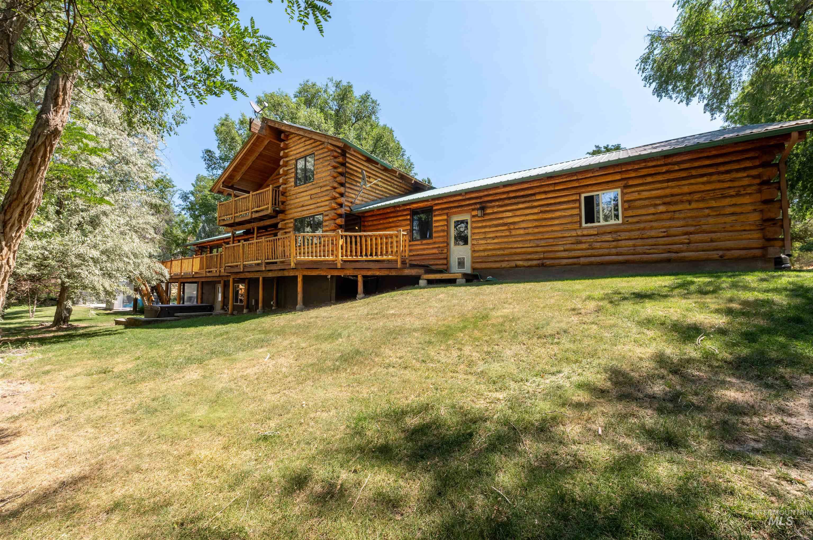 1314 River Road Buhl, ID 83316 - Photo 4 of 45 Back of house with log exterior, a deck, a lawn, and a metal roof