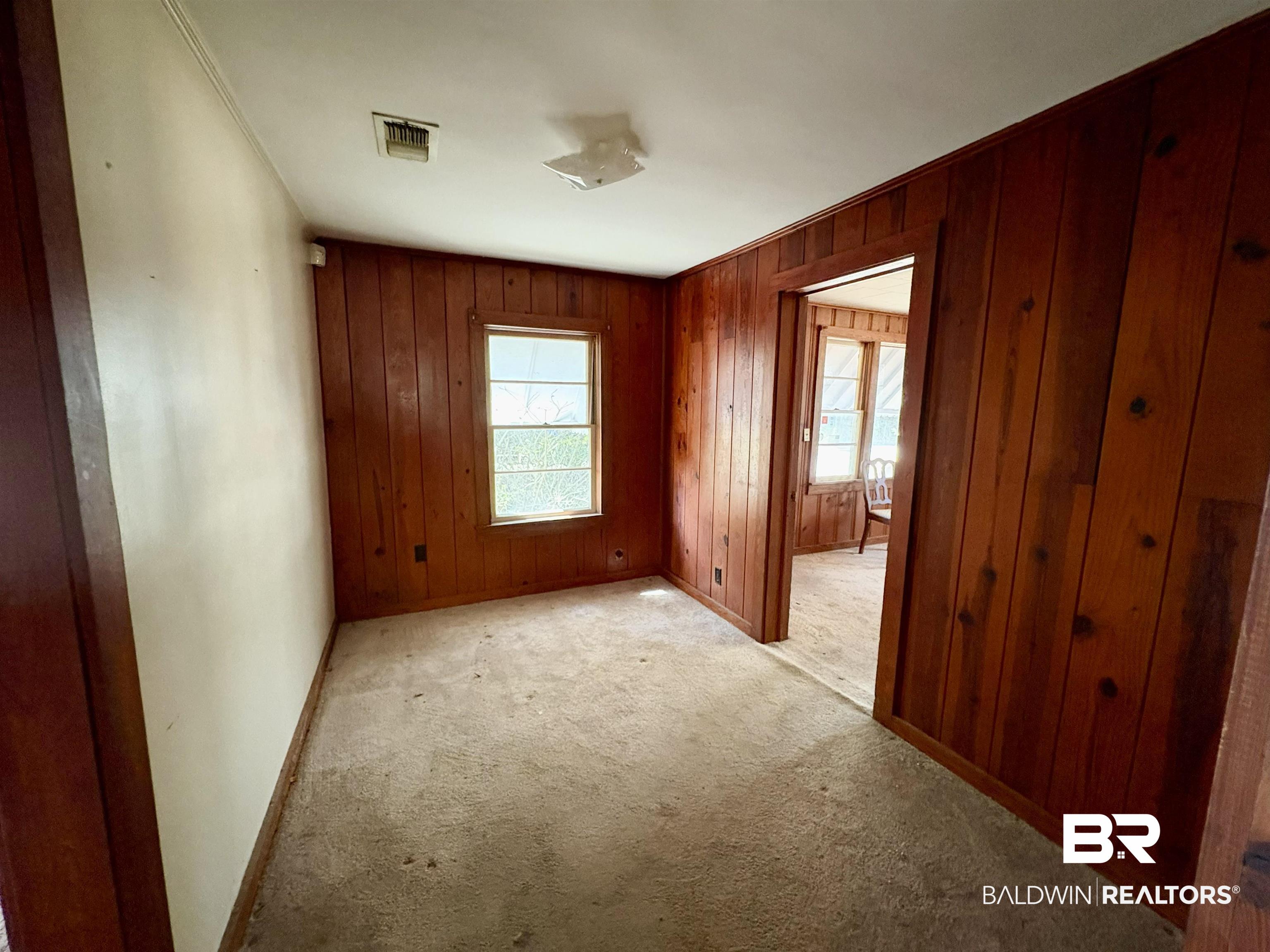 4060 Dickson Lane Mobile, AL 36618 - Photo 4 of 16 Unfurnished bedroom featuring wooden walls, carpet, and ornamental molding