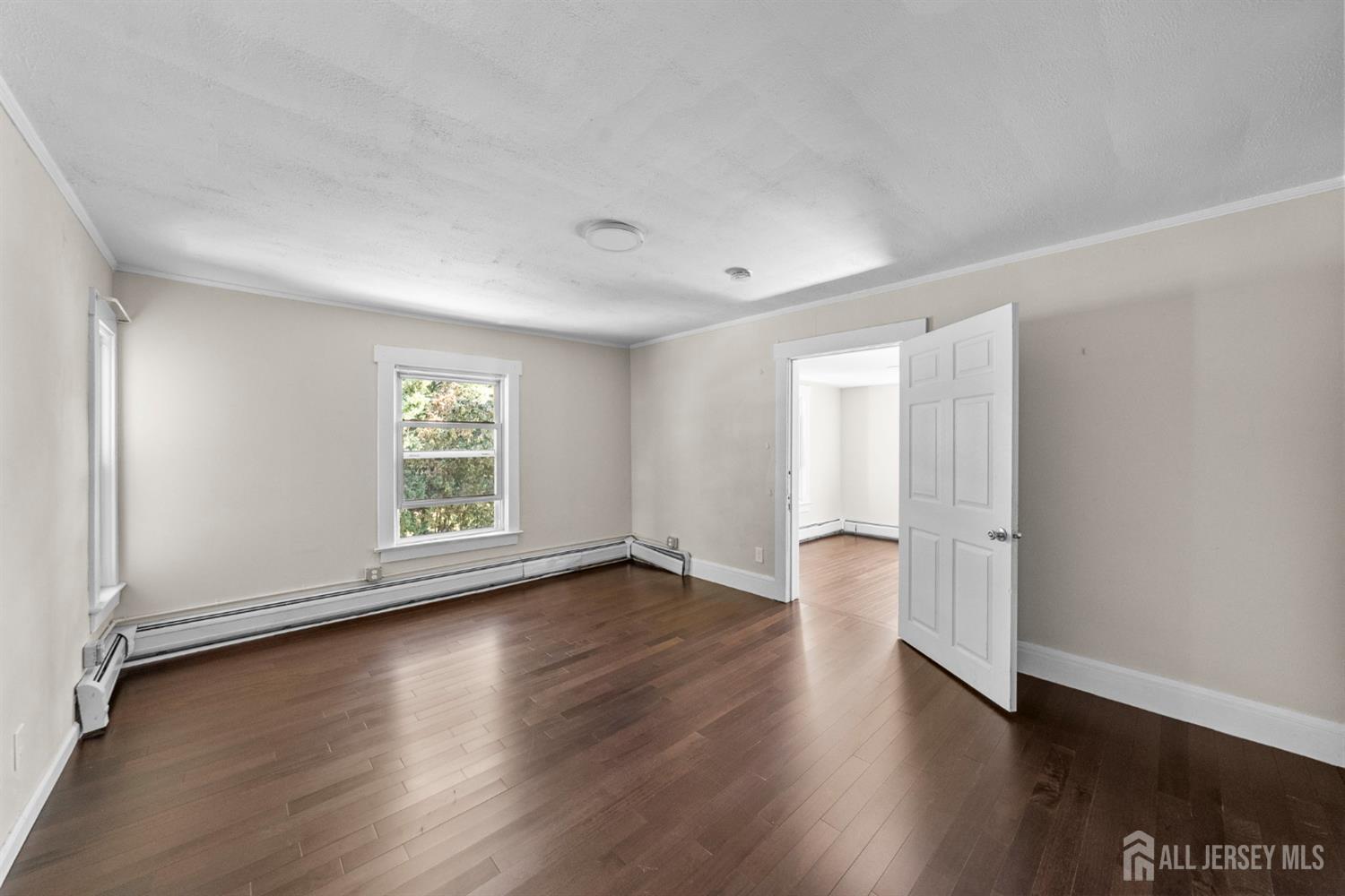1237 South 10th Street South Plainfield, NJ 07080 - Photo 11 of 23 an empty room with wooden floor and windows