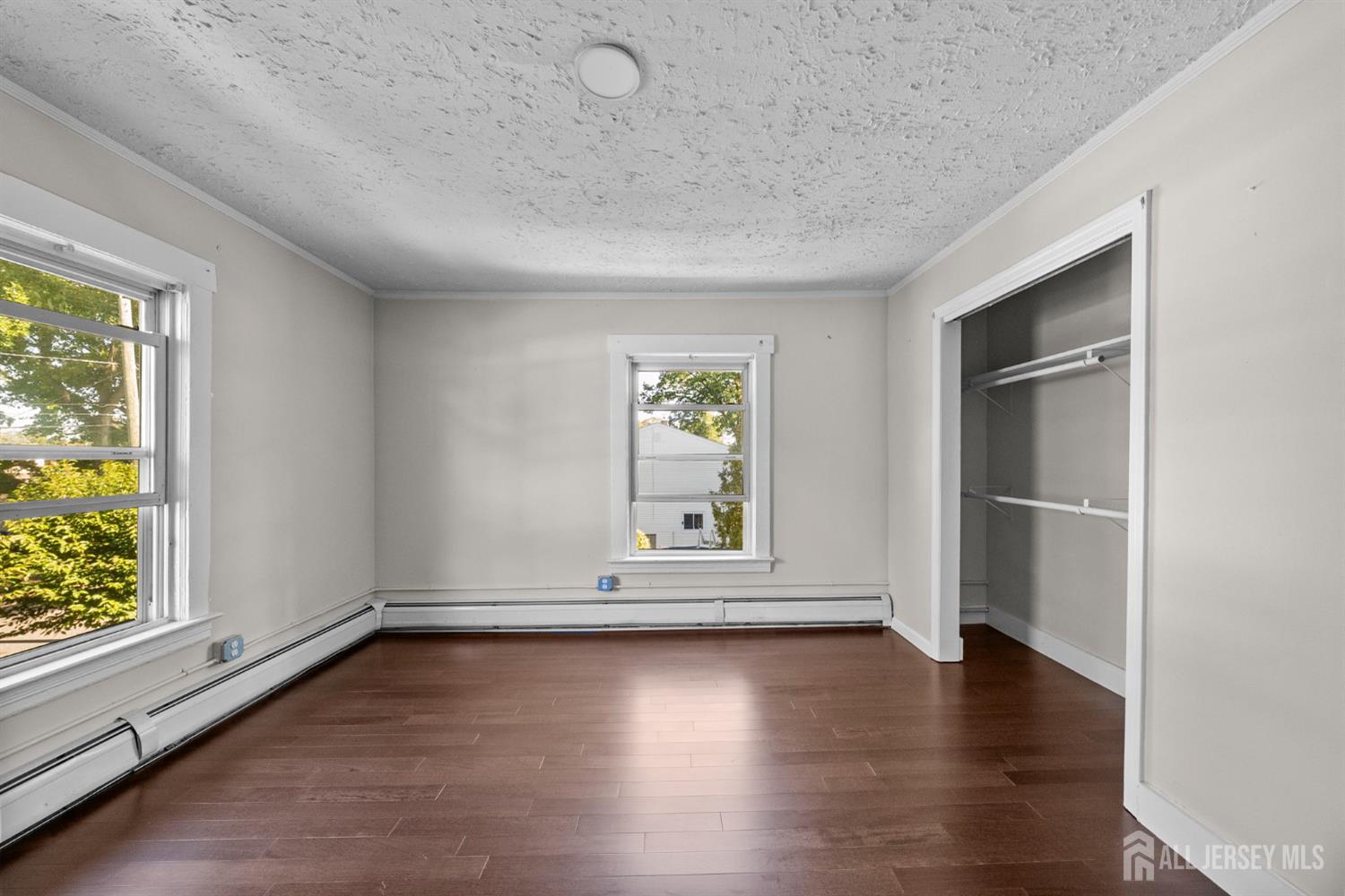 1237 South 10th Street South Plainfield, NJ 07080 - Photo 13 of 23 an empty room with wooden floor and windows