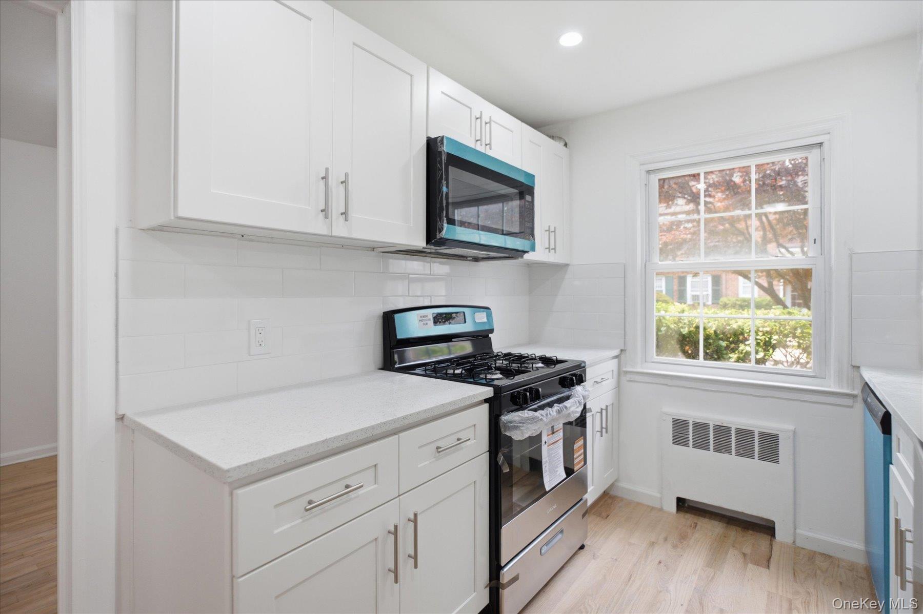 117 Robins Road, Unit 117 New Rochelle, NY 10801 - Photo 10 of 28 a kitchen with a stove and a microwave