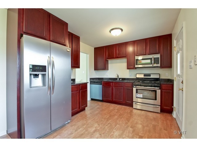 627 West Romeo Road Romeoville, IL 60446 - Photo 3 of 10 a kitchen with stainless steel appliances granite countertop a refrigerator stove and oven