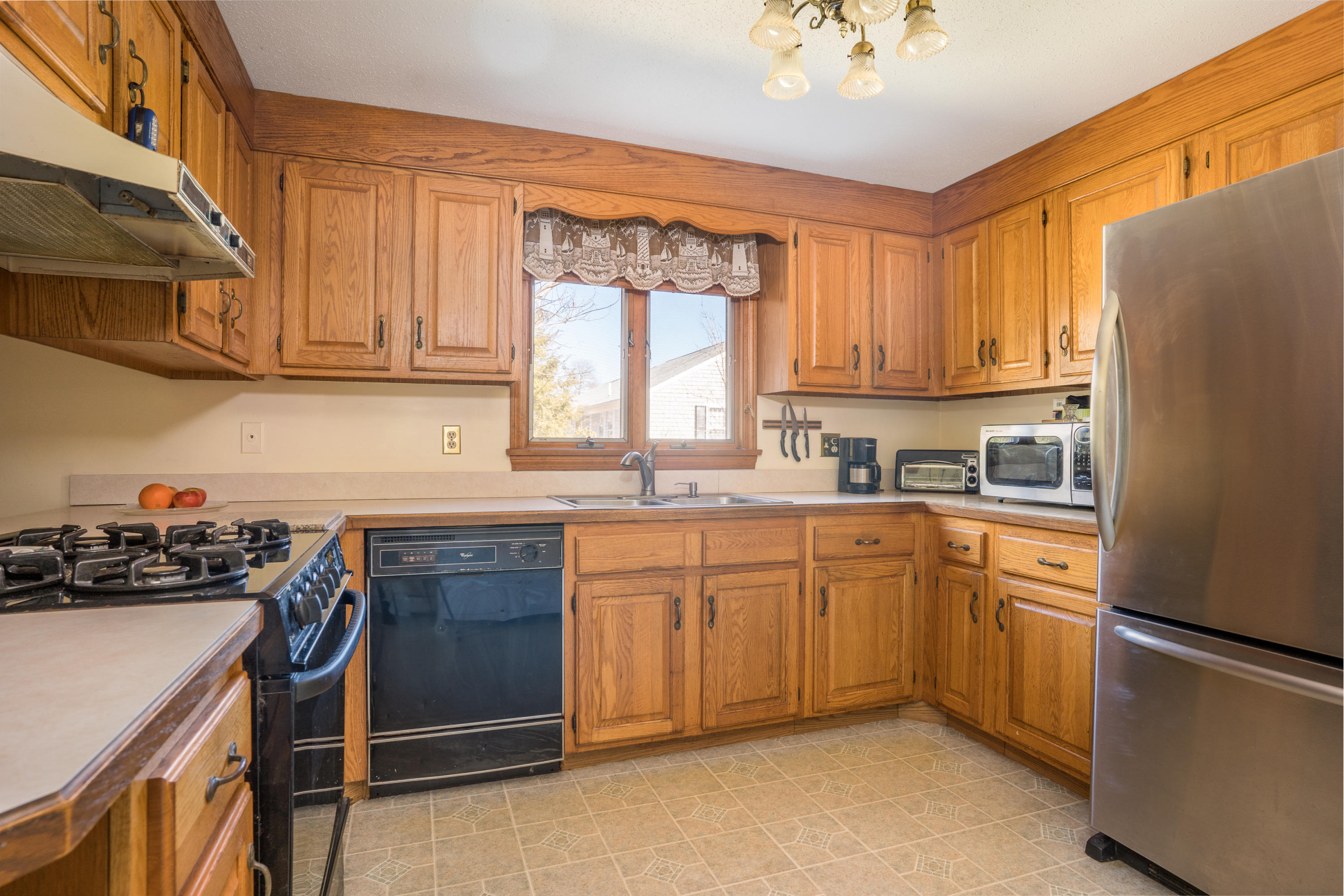 8 Black Valley Road Centerville, MA 02632 - Photo 9 of 15 a kitchen with stainless steel appliances granite countertop a refrigerator sink and wooden cabinets