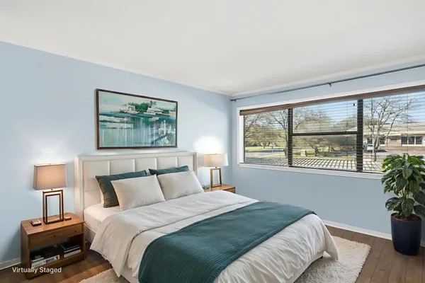 a bedroom with a bed and a large window