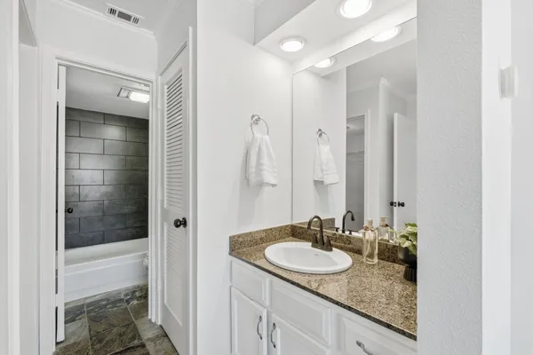 a bathroom with a granite countertop sink and a mirror