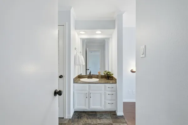a bathroom with a granite countertop sink and a mirror