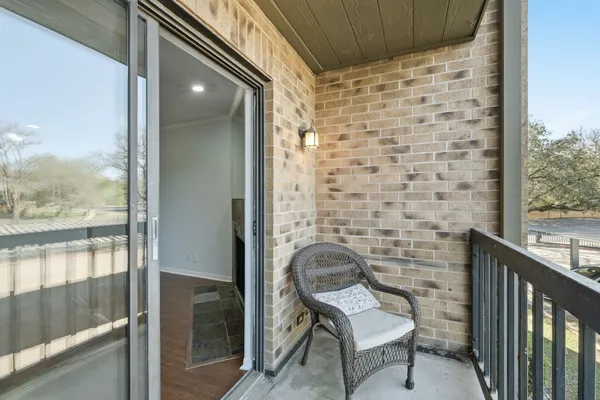 a brick building with a chair and a floor to ceiling window