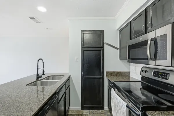 a kitchen with stainless steel appliances granite countertop a sink stove and refrigerator