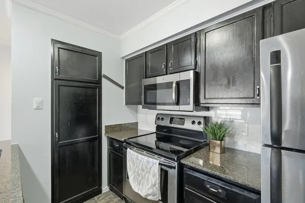 a kitchen with stainless steel appliances granite countertop a refrigerator a stove and a sink with wooden floor