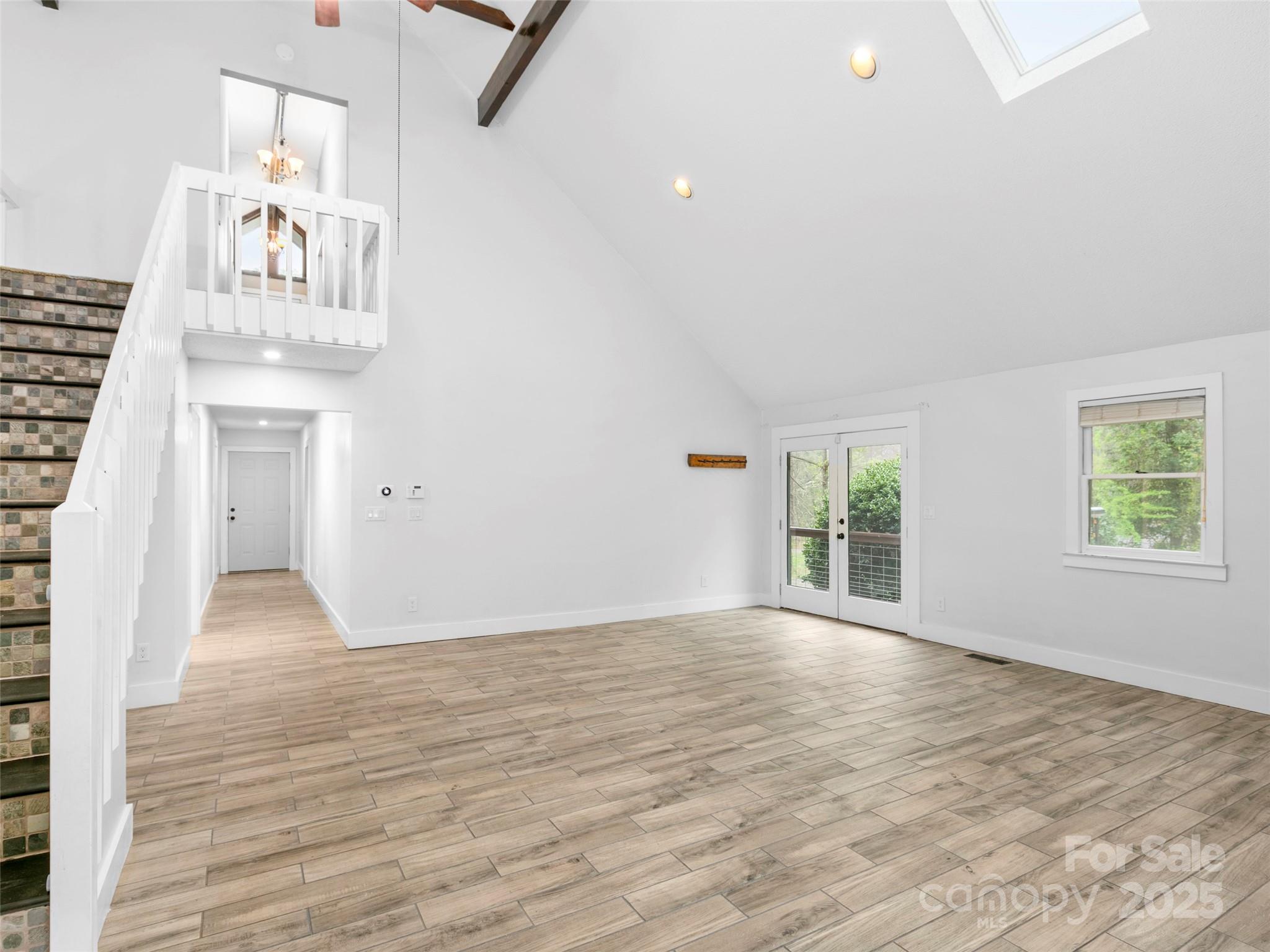 373 Vineyard Road Tryon, NC 28782 - Photo 11 of 46 an empty room with wooden floor and windows