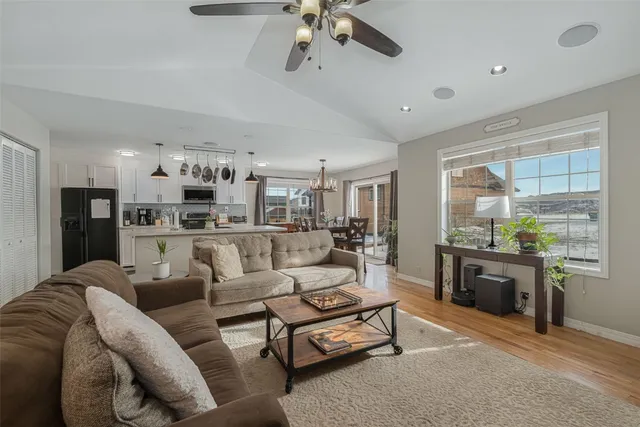 a living room with furniture kitchen view and a chandelier