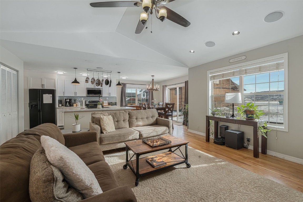 a living room with furniture kitchen view and a chandelier