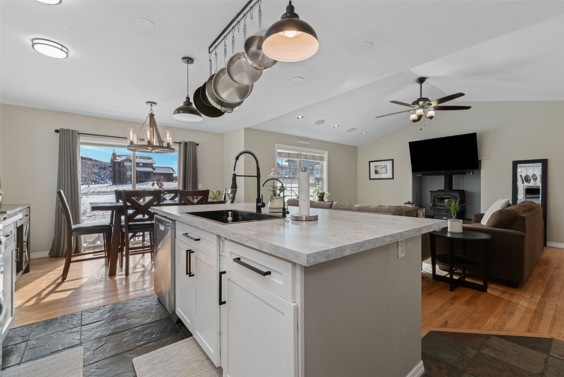 158 Oak Ridge Circle Oak Creek, CO 80467 - Photo 10 of 47 a kitchen with a sink dishwasher a stove top oven a dining table and chairs with wooden floor