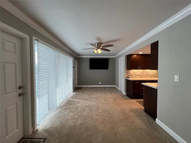 a view of furniture and kitchen with stainless steel appliances