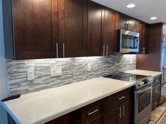 a kitchen with granite countertop wooden cabinets and stainless steel appliances