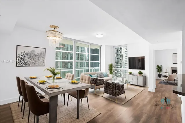 a living room with furniture a flat screen tv and a large window