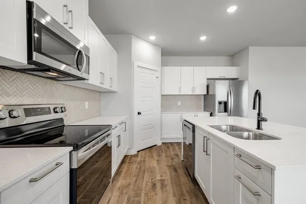 a kitchen with a sink stove and microwave