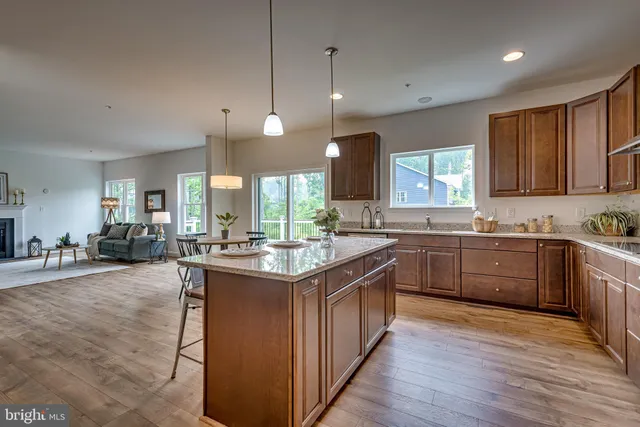 a kitchen with kitchen island granite countertop a sink appliances and cabinets