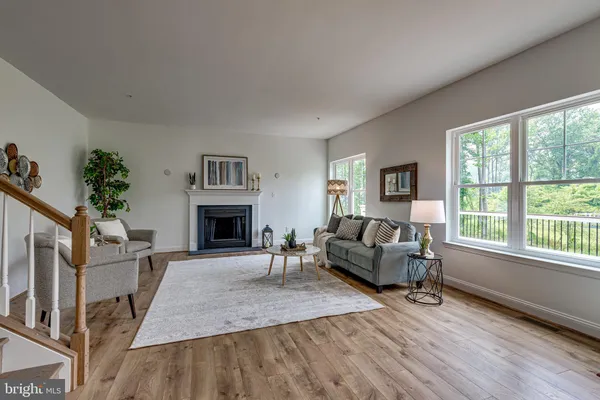 a living room with furniture a large window and a fireplace
