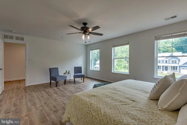a spacious bedroom with a bed a chandelier and a window