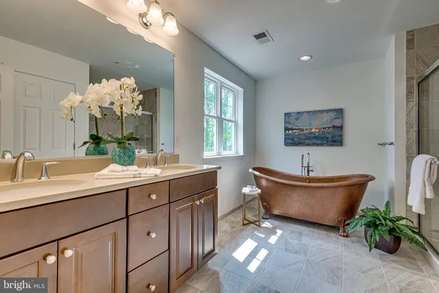 a spacious bathroom with a granite countertop sink mirror and bathtub