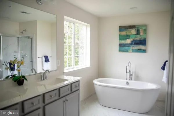 a bathroom with double vanity sinks a mirror and a window