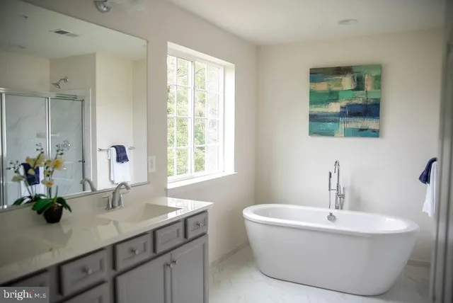 a bathroom with double vanity sinks a mirror and a window