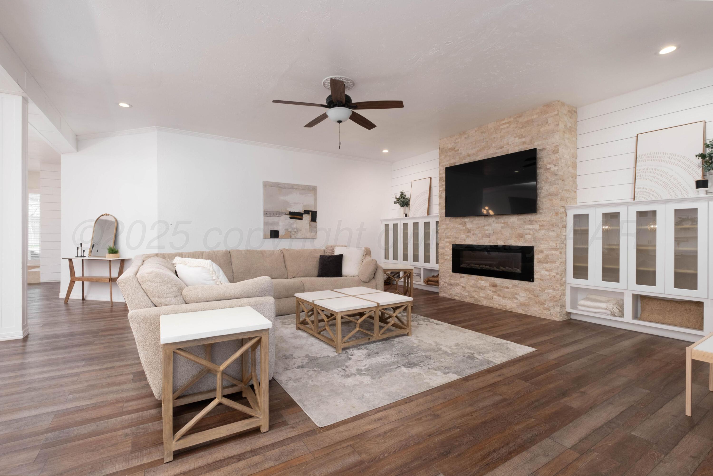 3207 Parker Street Amarillo, TX 79109 - Photo 18 of 73 a living room with furniture a flat screen tv and a fireplace