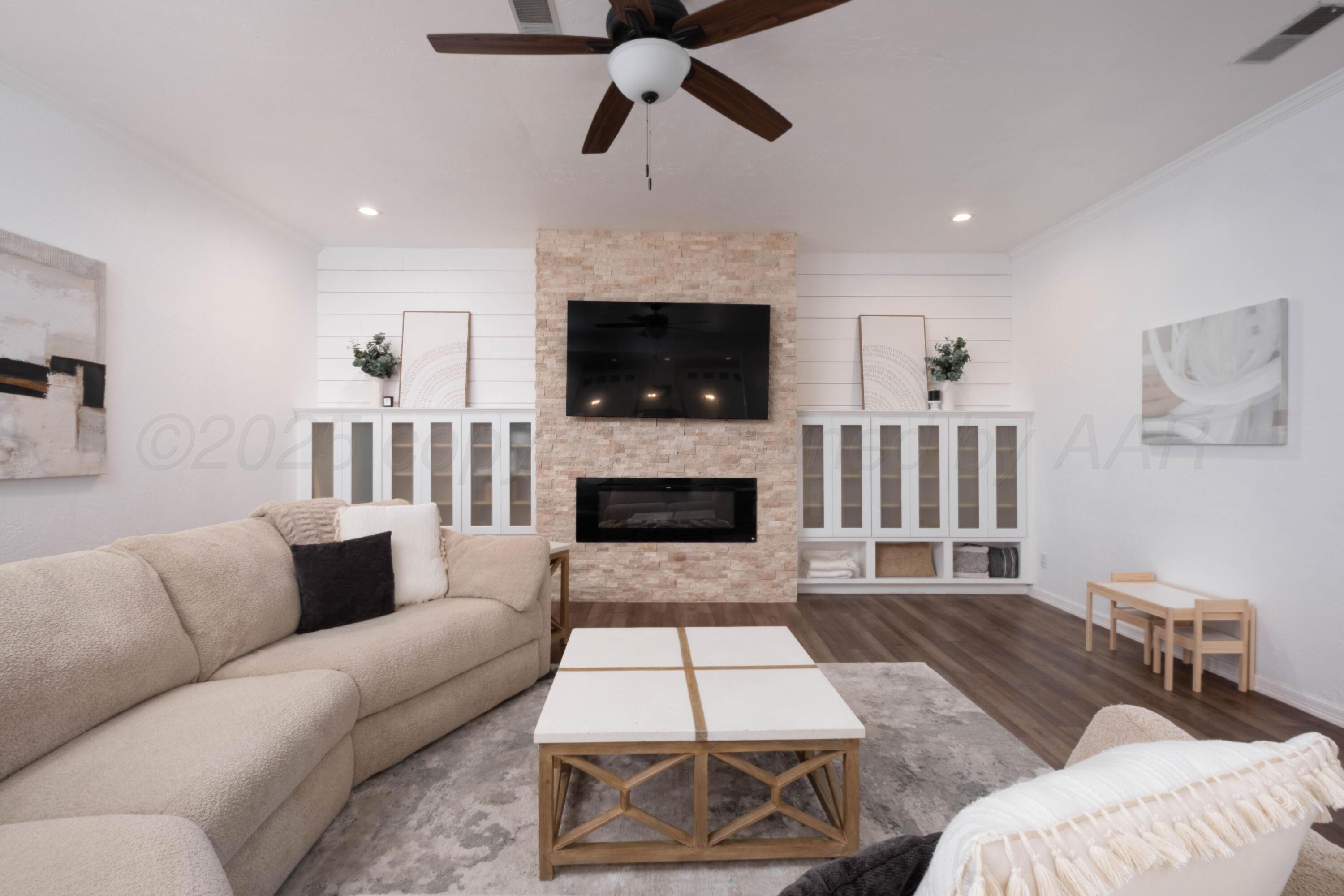 3207 Parker Street Amarillo, TX 79109 - Photo 19 of 73 a living room with furniture a flat screen tv and a fireplace